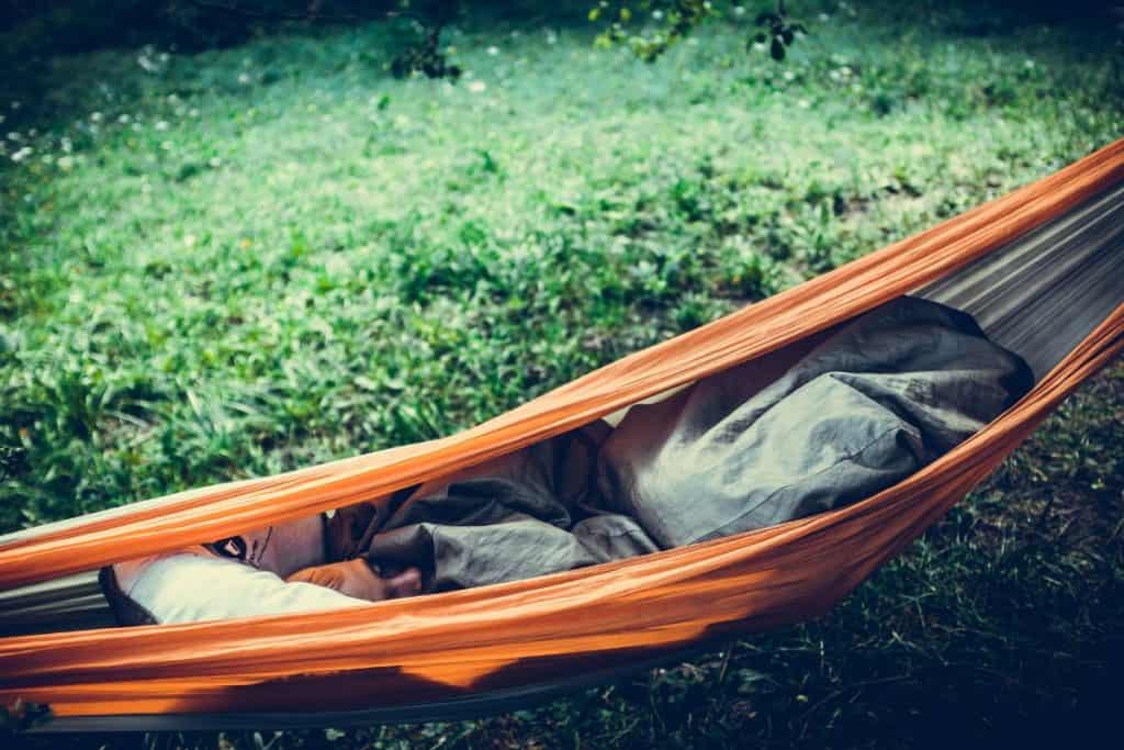 woman lying inside an orange hammock
