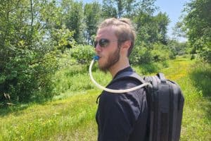 man in a prairie with a water bladder and backpack