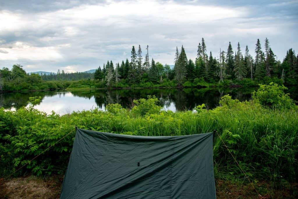 green tent by a lake