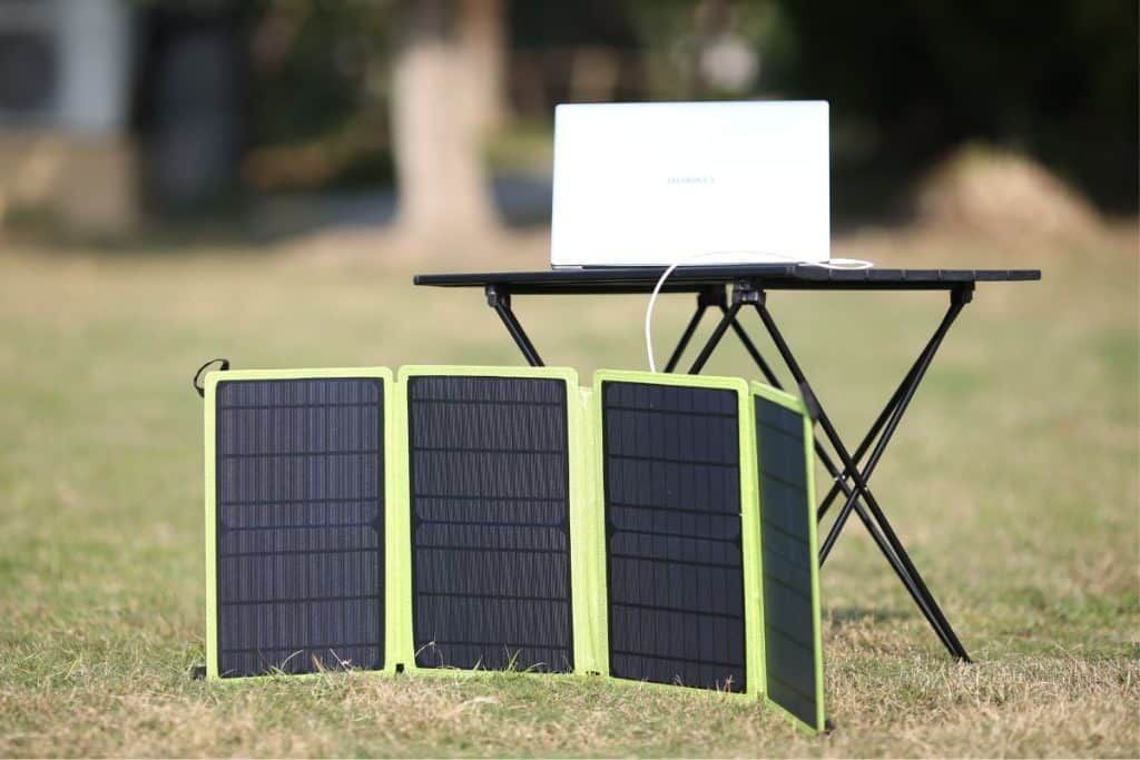 solar panels on grass with a white laptop on black table