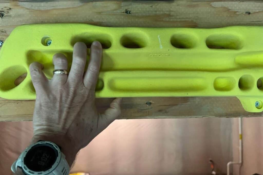 hand on a green hangboard