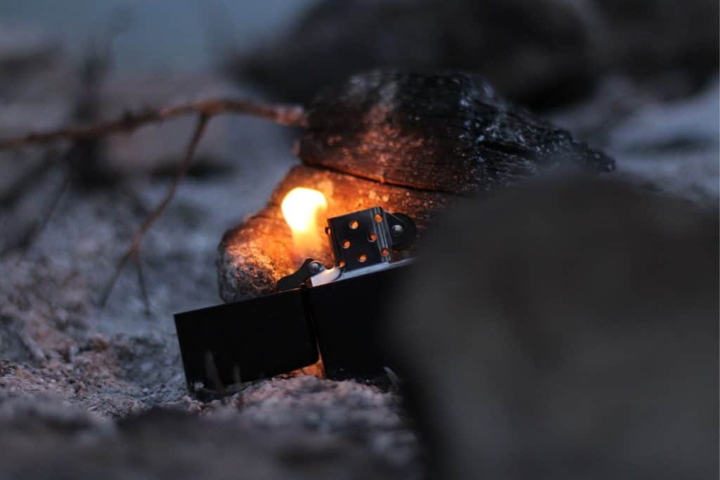 The Best Camping Lighter in 2023 2 zippo lighter in the sand by a rock