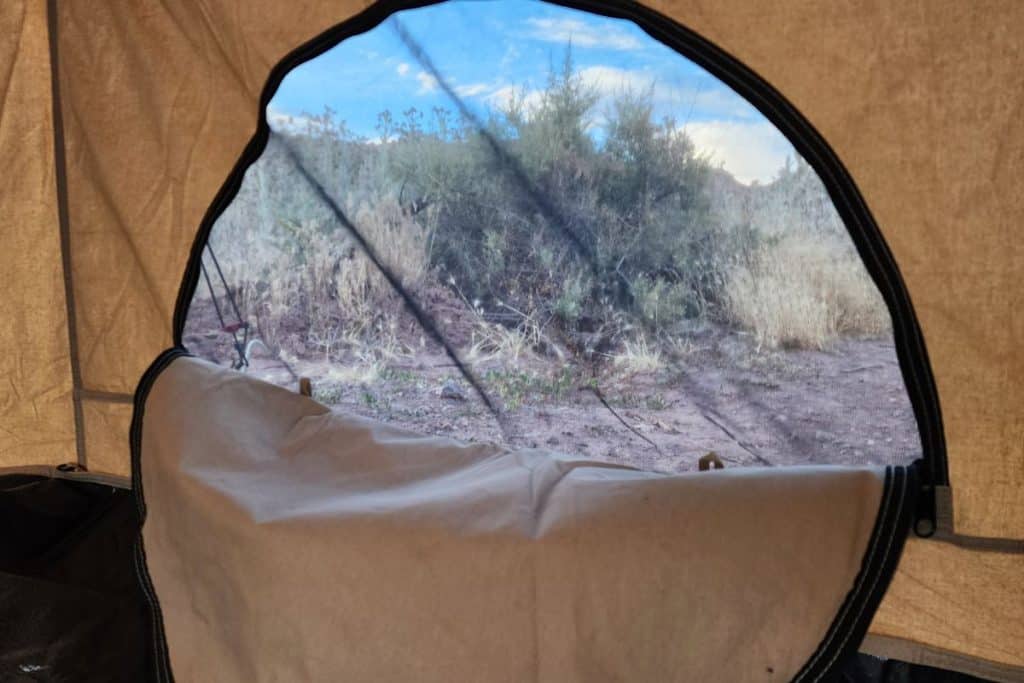 tent window covered in mesh in the desert