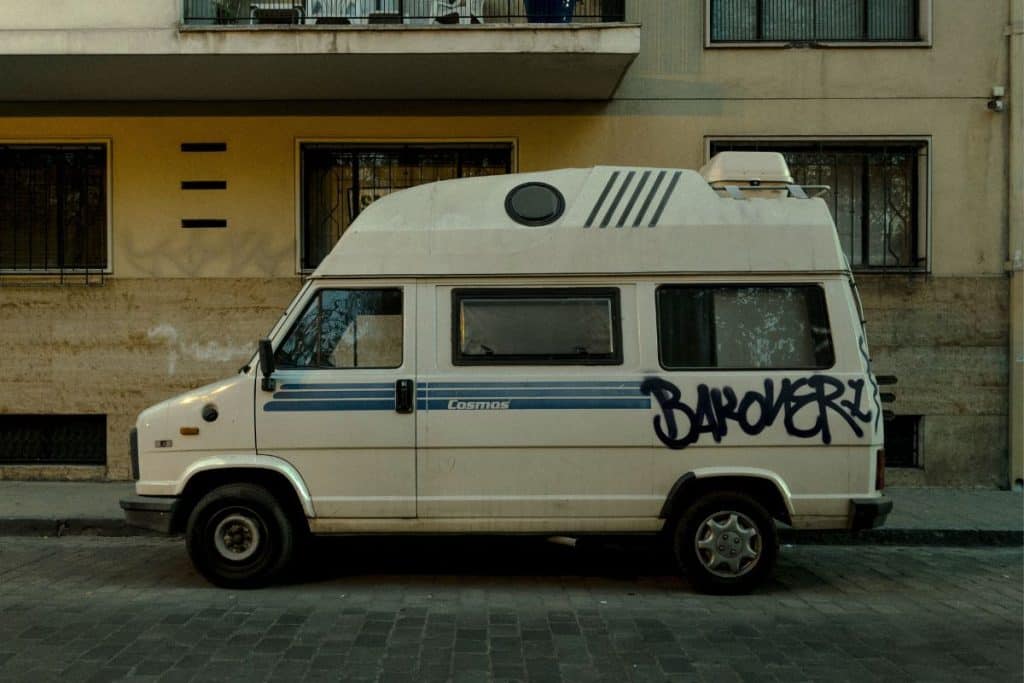 old white van with graffiti on it in a city