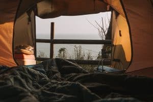 sleeping bag inside of a tent in front of a fence
