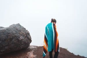 man wearing a towel by a rock