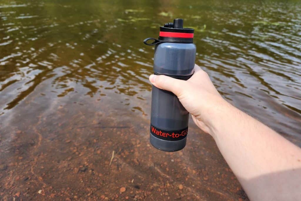 gray and red water bottle at a river