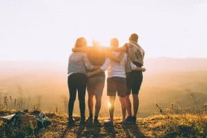 group of people standing in the sunset