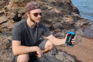 man holding a water filter while squatting