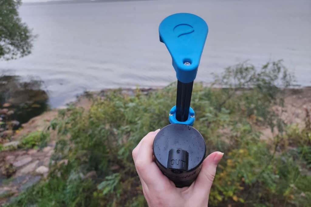 blue and black water pump filter by a lake