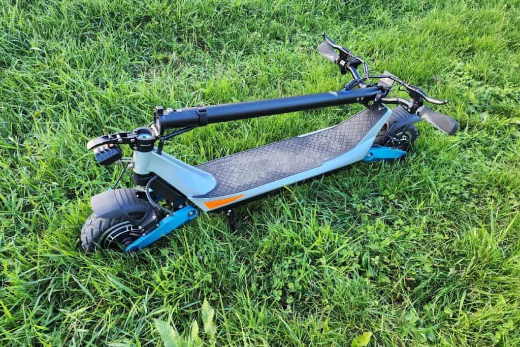 blue electric scooter folded on the grass