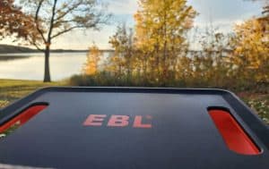 ebl black and orange power station outside by a lake