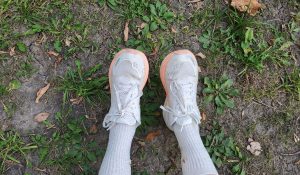 white sneakers over grass